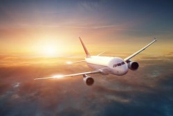 Airplane in the sky at sunset via fotolia