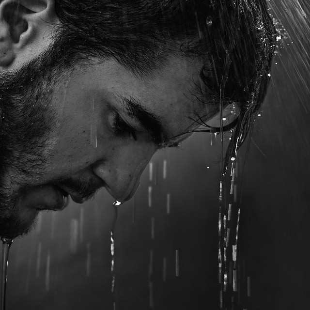 man rain wet sad strong pouring water face
