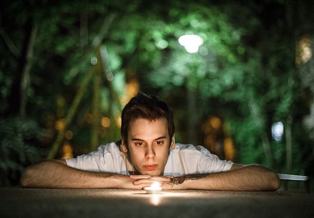 young man thinking meditating with candle 
