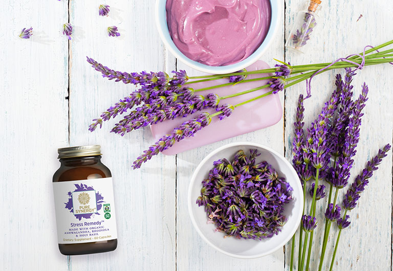 cosmetic cream, soap and purple lavender flowers on white wooden, top view