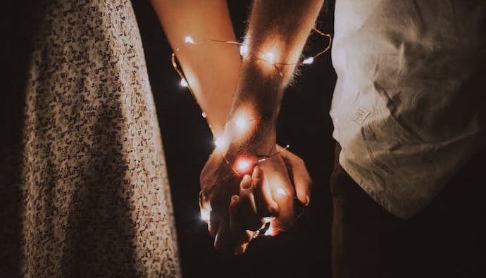 Anastasiya Lobanovskaya/Pexels https://www.pexels.com/photo/man-and-woman-holding-each-others-hand-wrapped-with-string-lights-792777/ | Elle Hari