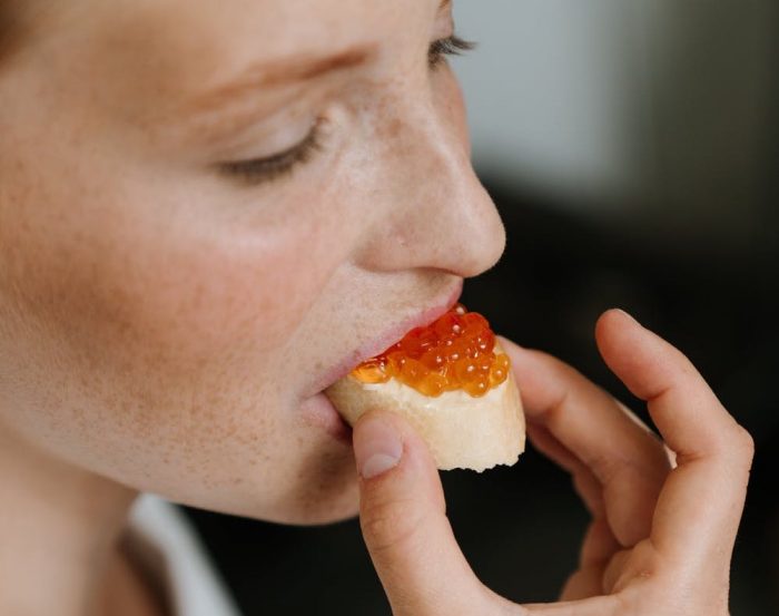 cottonbro/Pexels https://www.pexels.com/photo/woman-in-white-shirt-eating-bread-4973823/