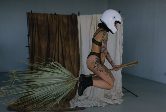 Anna Alexes/Pexels https://www.pexels.com/photo/woman-in-black-brassiere-and-white-skirt-sitting-on-brown-wooden-stick-8080185/